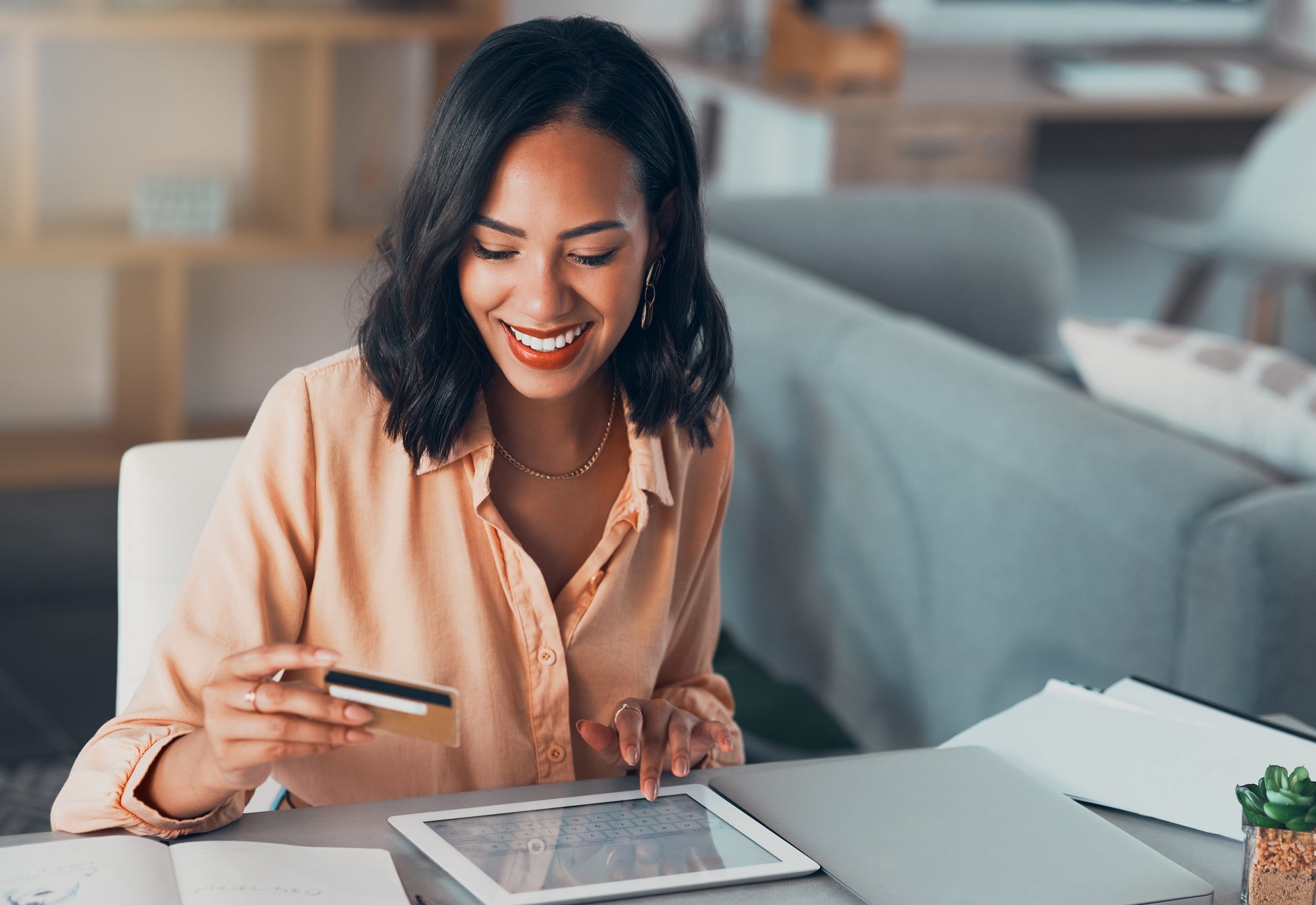 Lady with black hair ordering Liquid Youth products on a table with a credit card. 