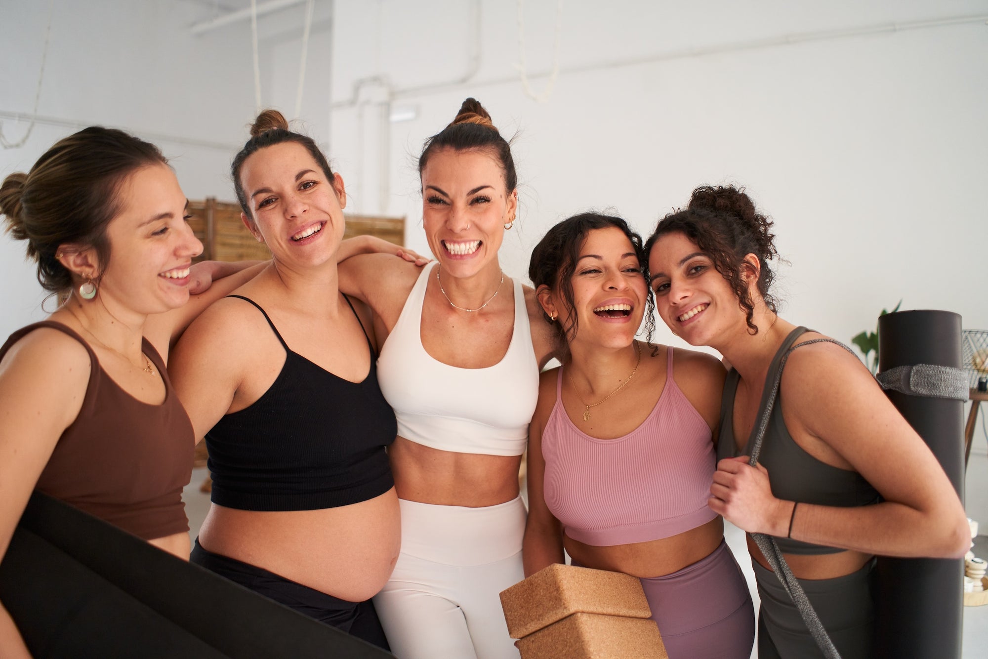 Group of beautiful women embracing after a workout. 